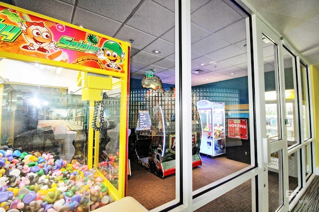 game room featuring a paneled ceiling and carpet