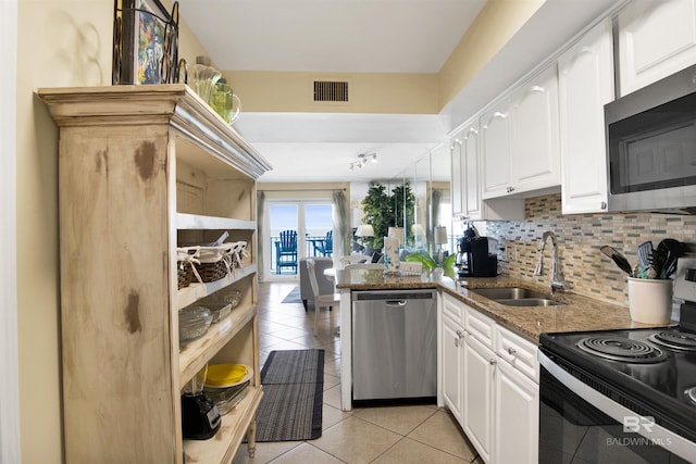 969 W Beach Blvd Unit 1503A, Gulf Shores, AL 36542 - kitchen featuring stainless steel appliances, dark stone counters, white cabinets, and light tile patterned floors