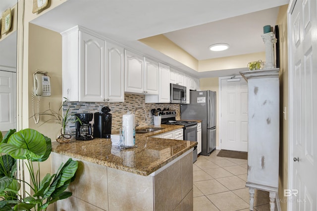 969 W Beach Blvd Unit 1503A, Gulf Shores, AL 36542 - kitchen with stainless steel appliances, stone counters, white cabinetry, decorative backsplash, and a peninsula