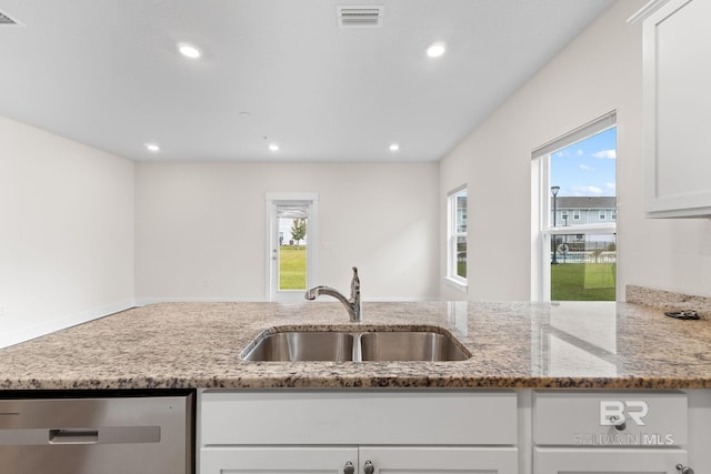 kitchen with sink, stainless steel dishwasher, white cabinets, and light stone counters