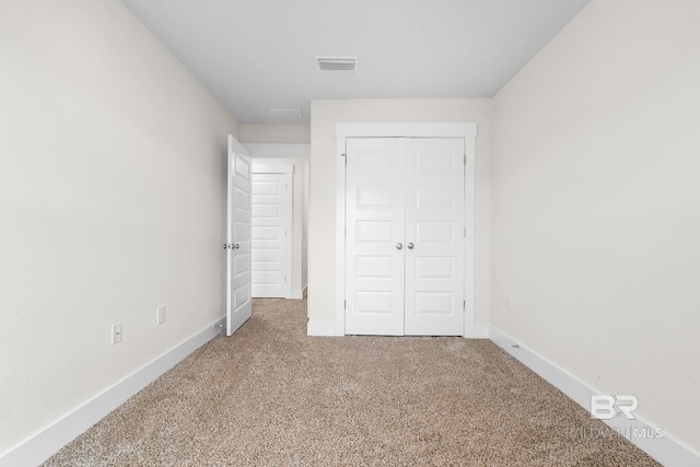 unfurnished bedroom featuring carpet floors and a closet