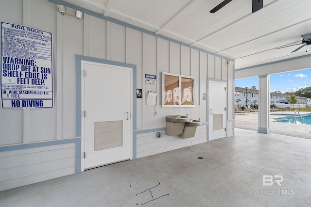 garage with a community pool and ceiling fan