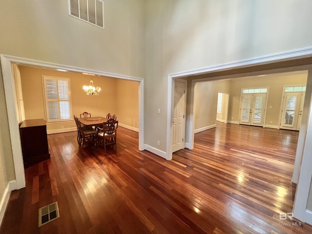 151 Mockingbird Ln, Atmore, AL 36502 - dining room with a towering ceiling, dark wood-style flooring, a chandelier, and baseboards