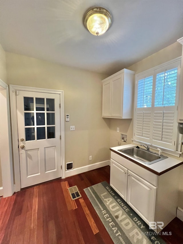 151 Mockingbird Ln, Atmore, AL 36502 - kitchen with a sink, dark wood-type flooring, white cabinets, baseboards, and light countertops