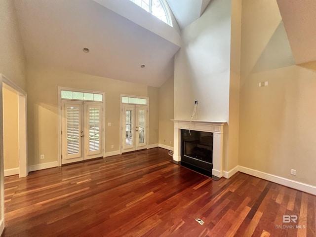 151 Mockingbird Ln, Atmore, AL 36502 - unfurnished living room featuring high vaulted ceiling, wood finished floors, a glass covered fireplace, and baseboards