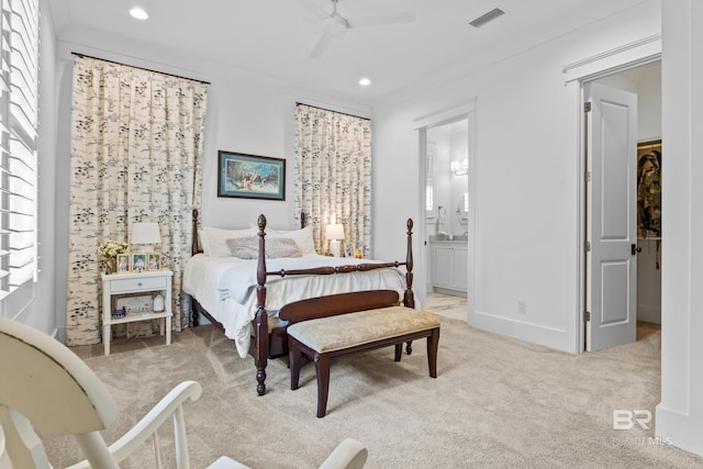 bedroom featuring ceiling fan, ensuite bath, light carpet, and ornamental molding