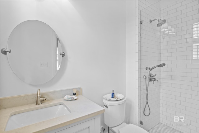 bathroom with vanity, toilet, and a tile shower