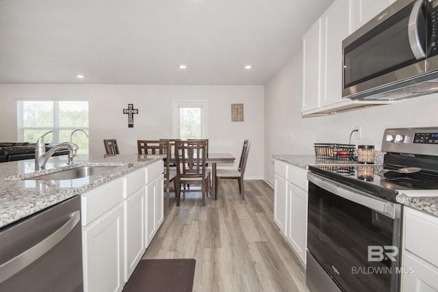 10909 Blacktail Loop, Pensacola, FL 32526 - kitchen with stainless steel appliances, light wood-style flooring, white cabinets, healthy amount of natural light, and recessed lighting