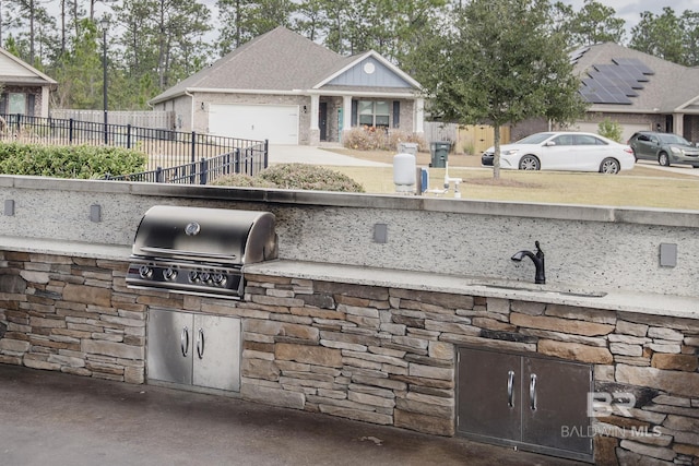 10909 Blacktail Loop, Pensacola, FL 32526 - view of patio featuring exterior kitchen, a garage, and driveway