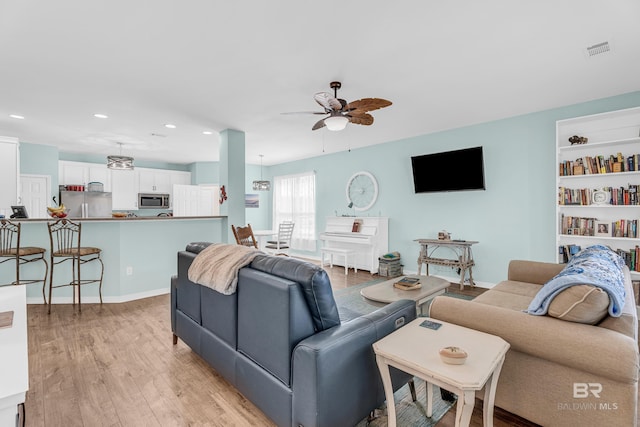 living area with a ceiling fan, visible vents, baseboards, light wood-style floors, and recessed lighting