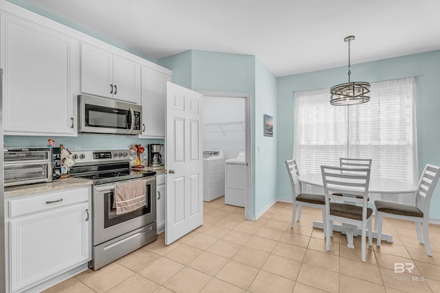 kitchen featuring washer and clothes dryer, stainless steel appliances, a toaster, light countertops, and a notable chandelier