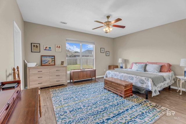 bedroom with baseboards, a ceiling fan, and wood finished floors