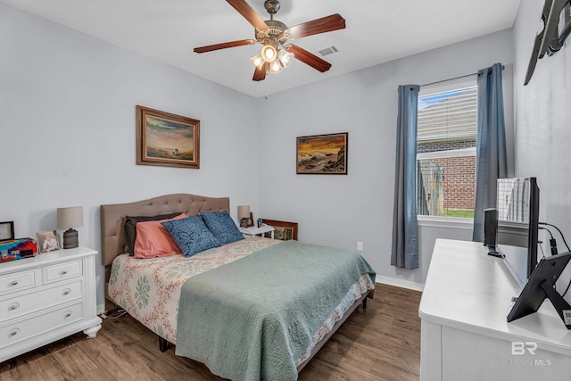 bedroom featuring baseboards, multiple windows, and wood finished floors