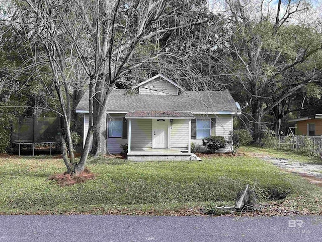 view of front of property featuring a front lawn and a trampoline