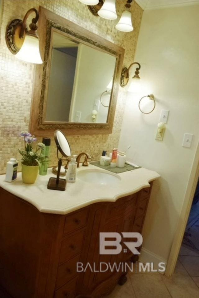 bathroom featuring vanity, ornamental molding, backsplash, and tile patterned flooring