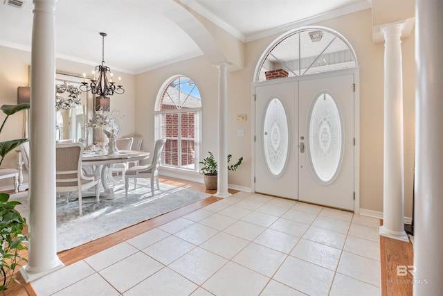 entrance foyer with light wood-type flooring, crown molding, and a chandelier