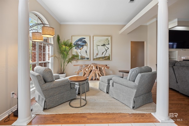 living room featuring ornate columns, hardwood / wood-style floors, and ornamental molding