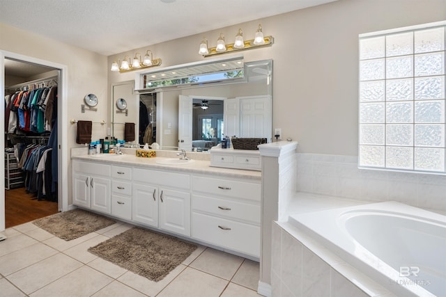 bathroom with tile patterned flooring, a textured ceiling, vanity, and plenty of natural light