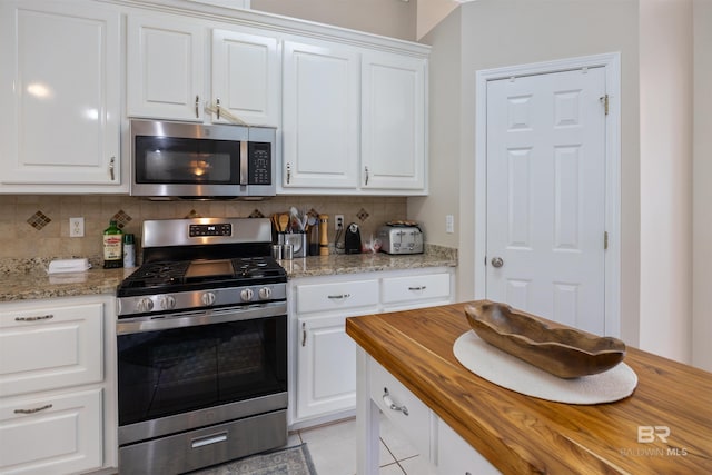 kitchen featuring light tile patterned floors, white cabinetry, appliances with stainless steel finishes, and tasteful backsplash