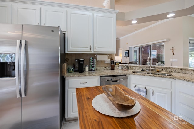 kitchen featuring white cabinetry, sink, backsplash, kitchen peninsula, and appliances with stainless steel finishes