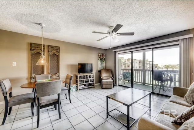 living room featuring light tile patterned floors, a ceiling fan, and a textured ceiling