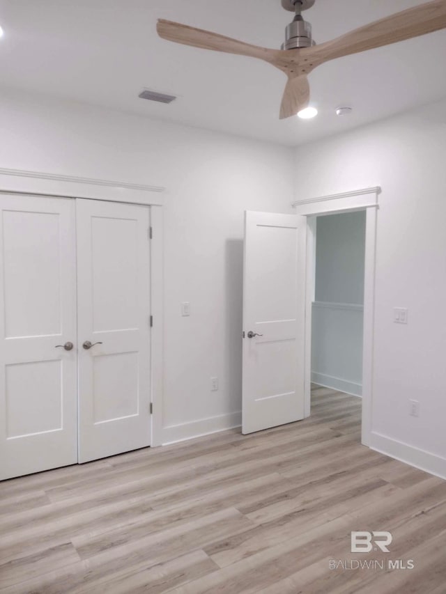 unfurnished bedroom featuring light hardwood / wood-style flooring, a closet, and ceiling fan