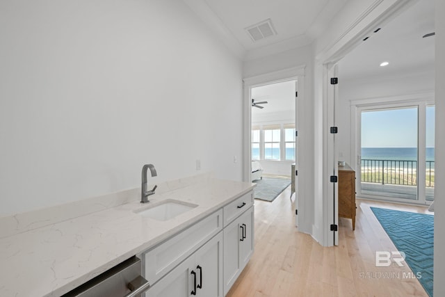 16761 Perdido Key Dr, Pensacola, FL 32507 - bar featuring light hardwood / wood-style floors, a water view, white cabinetry, light stone countertops, and stainless steel dishwasher