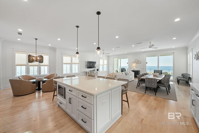 16761 Perdido Key Dr, Pensacola, FL 32507 - kitchen with light wood-type flooring, a center island, white cabinetry, decorative light fixtures, and ceiling fan