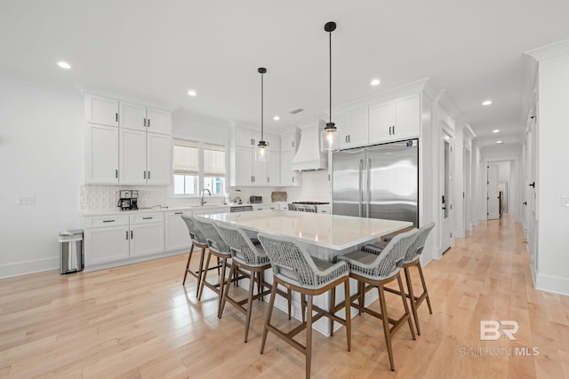 16761 Perdido Key Dr, Pensacola, FL 32507 - kitchen featuring light hardwood / wood-style flooring, appliances with stainless steel finishes, a center island, and premium range hood