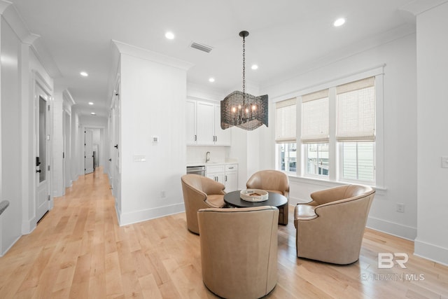 16761 Perdido Key Dr, Pensacola, FL 32507 - living area featuring ornamental molding, an inviting chandelier, sink, and light hardwood / wood-style floors