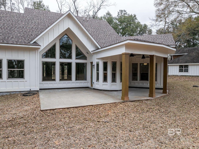 back of house featuring a patio area, ceiling fan, board and batten siding, and roof with shingles