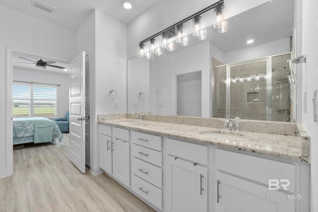 4175 Montague Dr, Gulf Shores, AL 36542 - ensuite bathroom featuring double vanity, a shower stall, wood finished floors, a ceiling fan, and recessed lighting