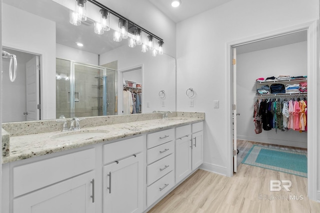 4175 Montague Dr, Gulf Shores, AL 36542 - full bathroom with a spacious closet, double vanity, a shower stall, wood finished floors, and recessed lighting