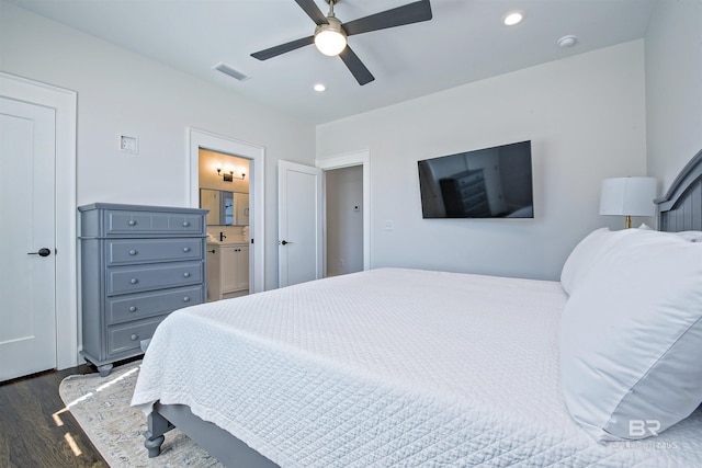 bedroom featuring ceiling fan, connected bathroom, and dark hardwood / wood-style flooring