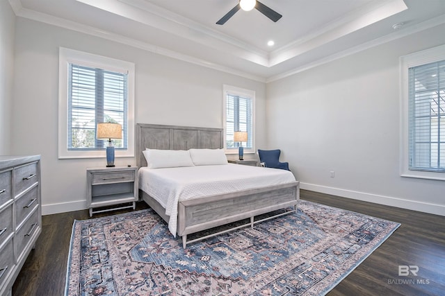 bedroom featuring multiple windows, dark hardwood / wood-style floors, ceiling fan, and a tray ceiling