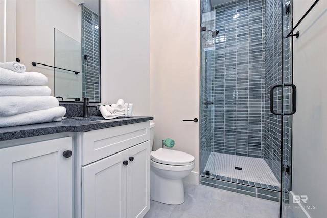 bathroom featuring tile patterned floors, vanity, toilet, and an enclosed shower