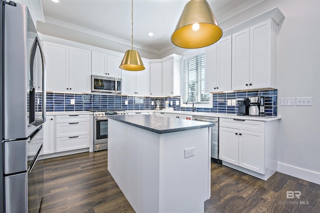 kitchen with stainless steel appliances, a kitchen island, pendant lighting, and white cabinets