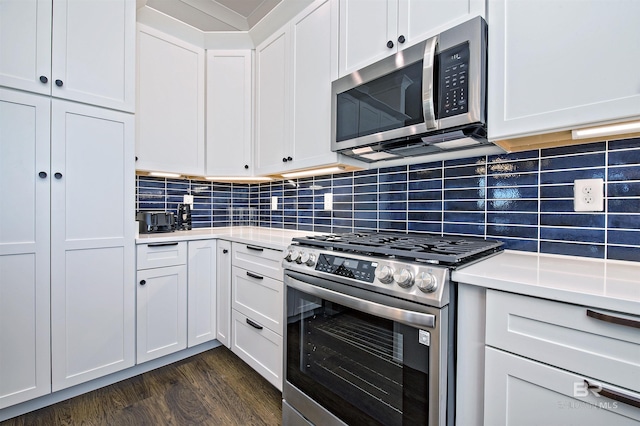 kitchen with tasteful backsplash, dark wood-type flooring, stainless steel appliances, and white cabinets