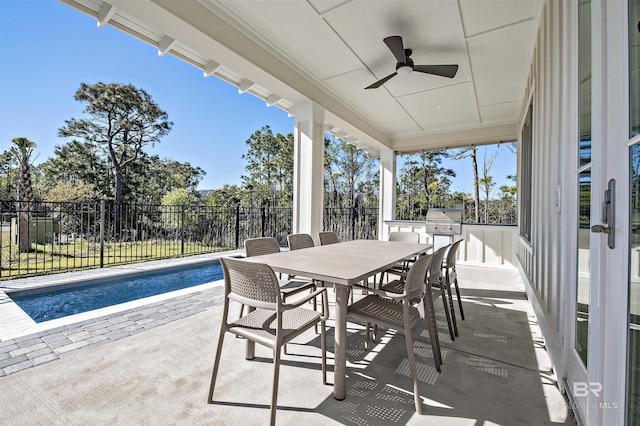 view of patio / terrace featuring area for grilling, a fenced in pool, ceiling fan, and exterior kitchen