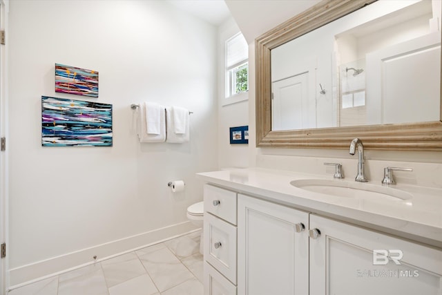 bathroom featuring tile flooring, vanity, and toilet