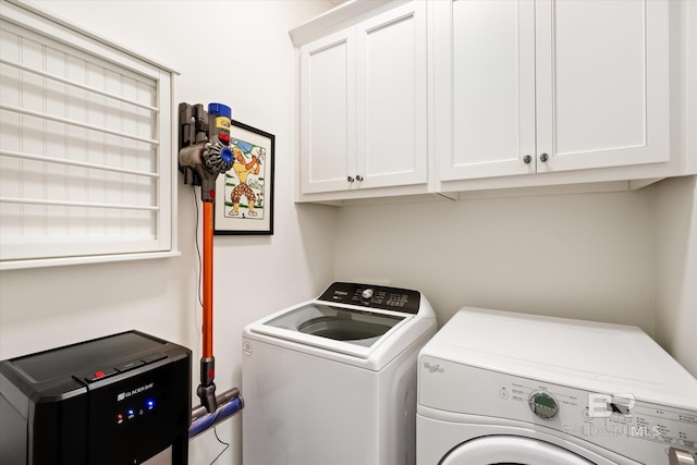 laundry area with washing machine and dryer and cabinets