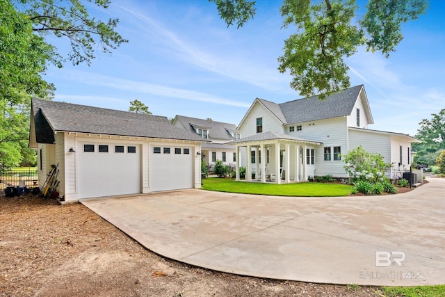 view of front of property with central AC, a front lawn, and a garage