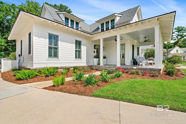 view of front of property featuring ceiling fan and a front lawn