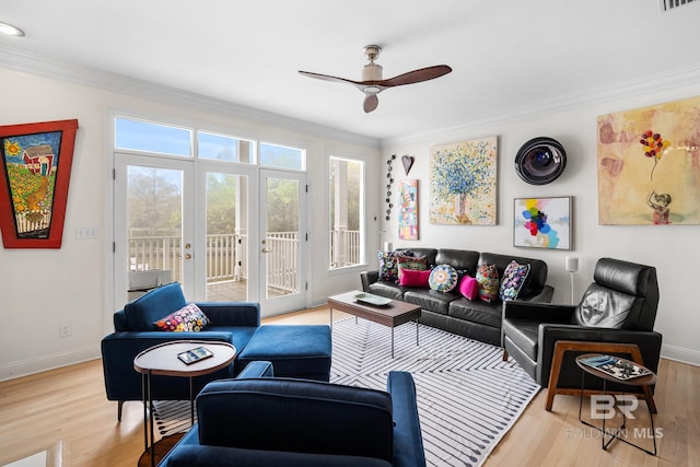 living area with ceiling fan, wood finished floors, french doors, and crown molding