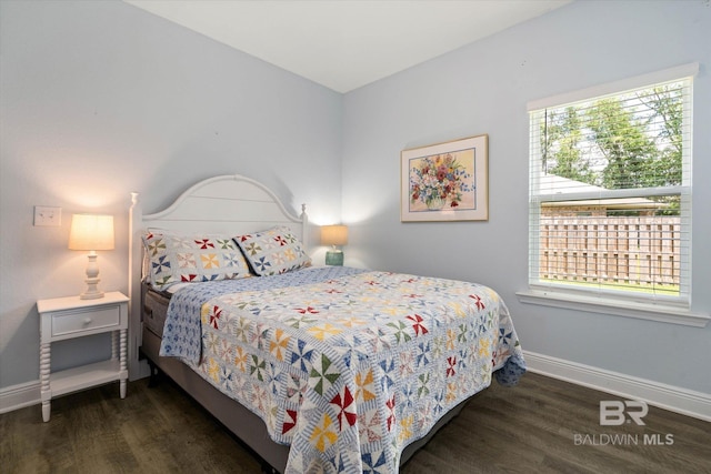 bedroom with wood finished floors and baseboards