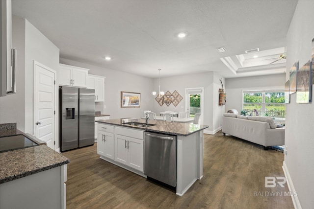 kitchen with appliances with stainless steel finishes, a sink, dark wood-type flooring, open floor plan, and recessed lighting