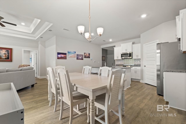 dining space with recessed lighting, ceiling fan, wood finished floors, a chandelier, and ornamental molding