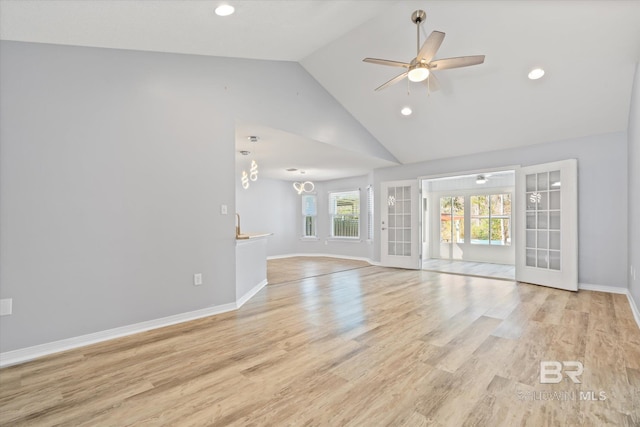 unfurnished living room with light hardwood / wood-style flooring, high vaulted ceiling, french doors, and ceiling fan