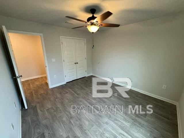 32807 N Pickens Ave, Lillian, AL 36549 - unfurnished bedroom featuring wood finished floors, baseboards, a closet, and a ceiling fan