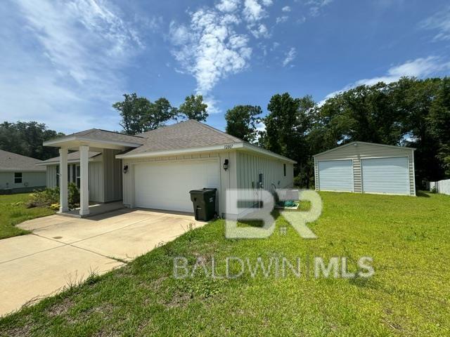 32807 N Pickens Ave, Lillian, AL 36549 - view of home's exterior featuring board and batten siding, a garage, and a yard